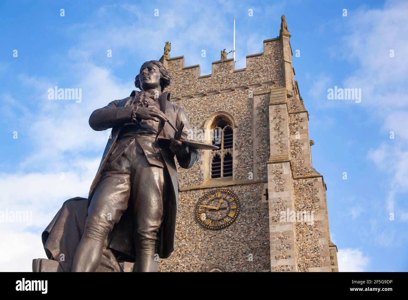 A statue of artist painter Thomas Gainsborough with brush and palette stands in the market-place, in front of St Peter's Church, Sudbury, Suffolk. Stock Photo