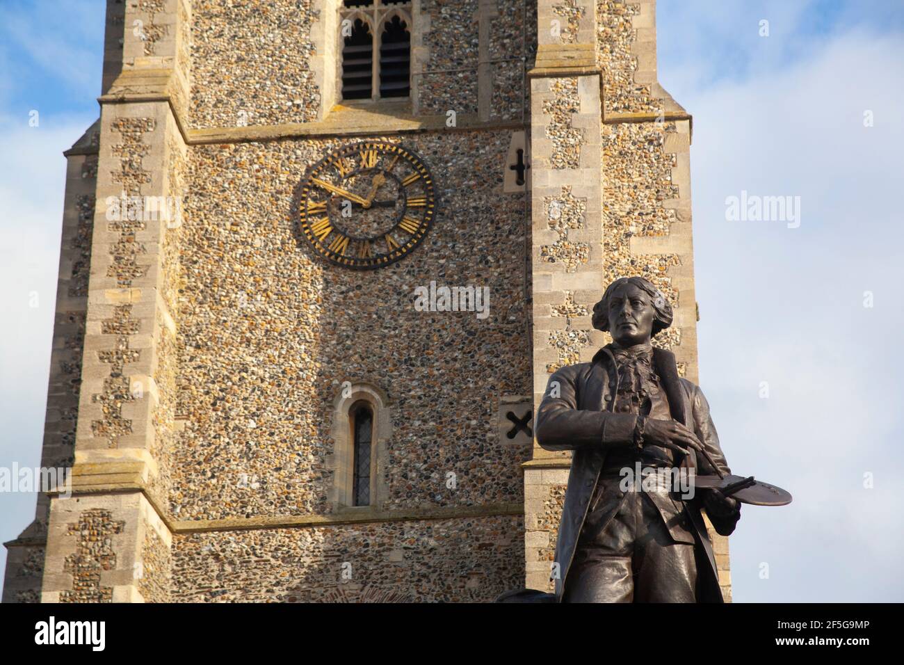 A statue of artist painter Thomas Gainsborough with brush and palette stands in the market-place, in front of St Peter's Church, Sudbury, Suffolk. Stock Photo