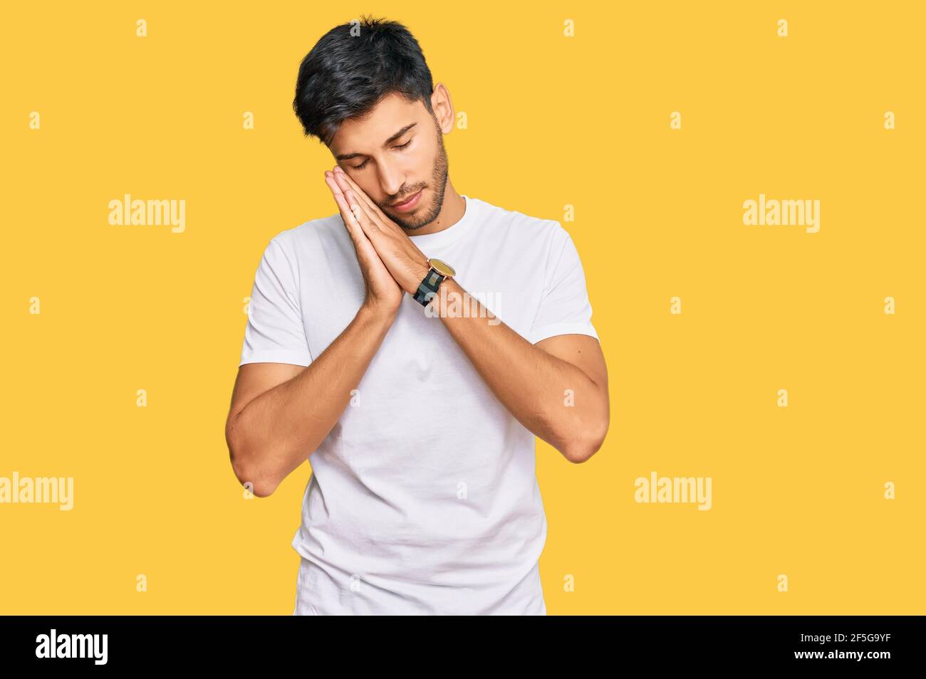 Young handsome man wearing casual white tshirt sleeping tired dreaming ...