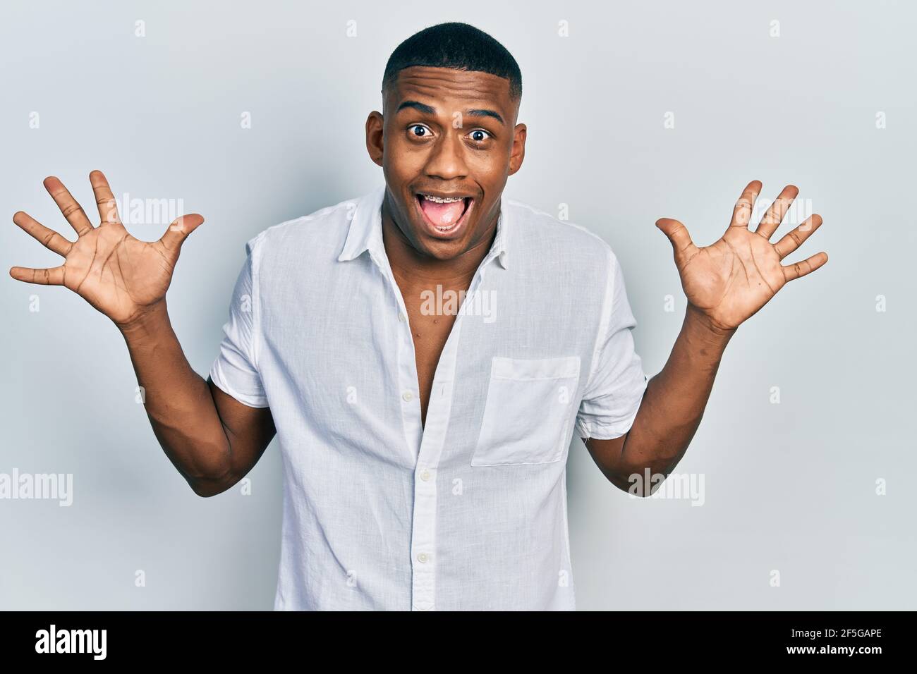 Young black man wearing casual white shirt celebrating crazy and amazed ...