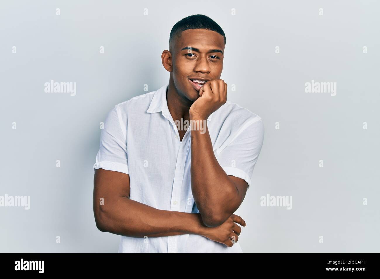 Young black man wearing casual white shirt looking stressed and nervous ...