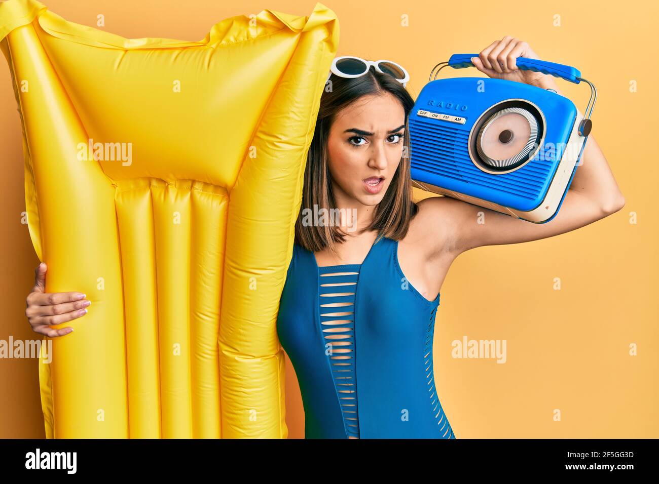 Young brunette girl wearing bikini holding boombox and float in shock ...