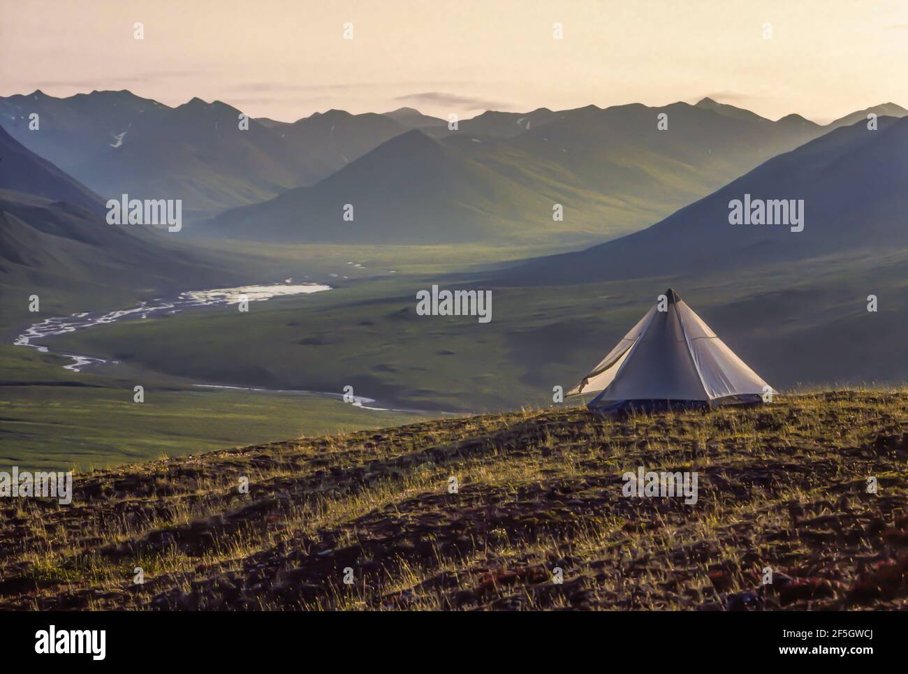 Backpacking tent overlooking a river valley in the arctic tundra of