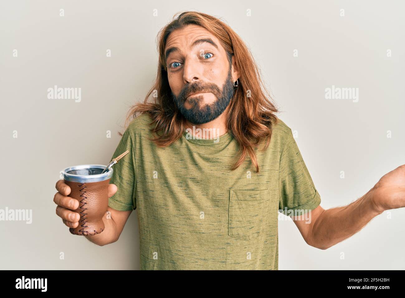 Attractive man with long hair and beard drinking mate infusion ...