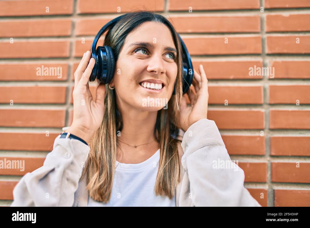 Young caucasian woman smiling happy listening to music using headphones ...