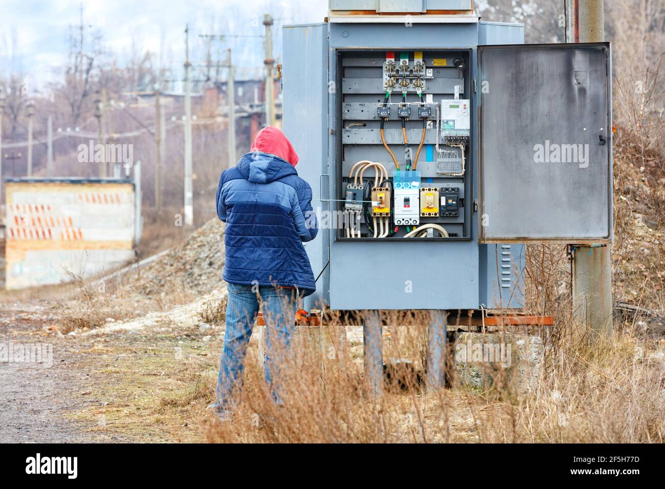 Transformer substation stands in the middle of the garden against a blue cloudy sky. Stock Photo