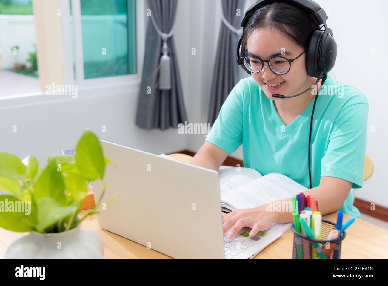 Portrait Asian young woman student with glasses headphones to study ...