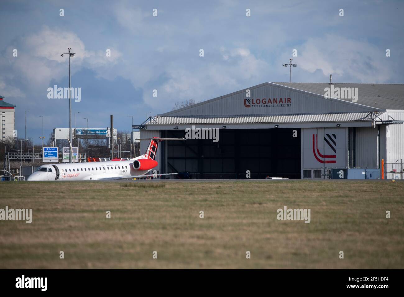Glasgow, Scotland, UK. 26th Mar, 2021. PICTURED: Loganair Embraer 145 aircraft seen outside of its Glasgow based ops with the Loganair hangar in the background. The company is keeping its aircraft regularly maintained and flying throughout the pandemic. Credit: Colin Fisher/Alamy Live News Stock Photo