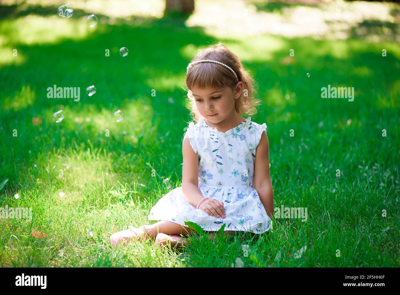 https://c8.alamy.com/comp/2F5HH6F/portrait-of-a-smiling-little-girl-sitting-on-green-grass-2F5HH6F.jpg