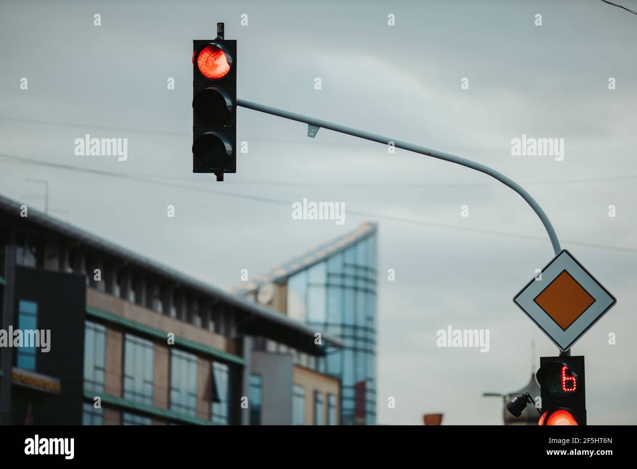 Main road sign and traffic light with a burning red signal for cars ...