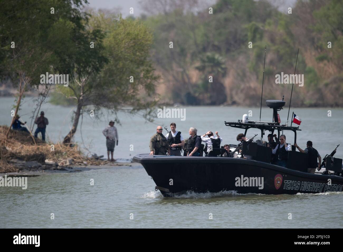 Granjeno, Texas USA, 26th Mar, 2021. With Mexico in the background, a delegation of Republican senators ride on the Rio Grande River south of Mission in a heavily armed Texas Dept. of Public Safety gunboat. During their whirlwind tour of south Texas, the 18 senators saw an overcrowded migrant processing center in Donna and a corpse floating in the river north of Anzalduas Park. Credit: Bob Daemmrich/Alamy Live News Stock Photo