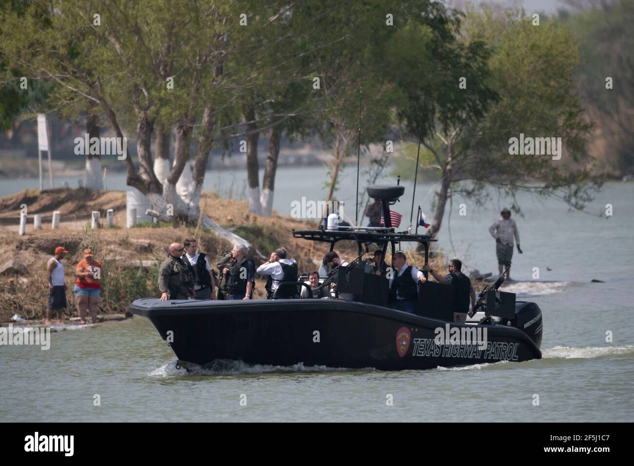 Granjeno, Texas USA, 26th Mar, 2021. With Mexico in the background, a delegation of Republican senators ride on the Rio Grande River south of Mission in a heavily armed Texas Dept. of Public Safety gunboat. During their whirlwind tour of south Texas, the 18 senators saw an overcrowded migrant processing center in Donna and a corpse floating in the river north of Anzalduas Park. Credit: Bob Daemmrich/Alamy Live News Stock Photo