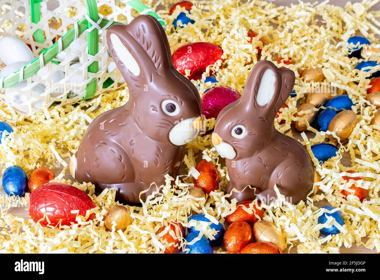 Easter. Two chocolate bunnies on straw, with easter eggs Stock Photo