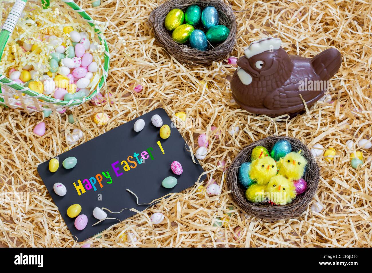 Easter, decoration on the straw. Chocolate Easter egg hen, and slate ...