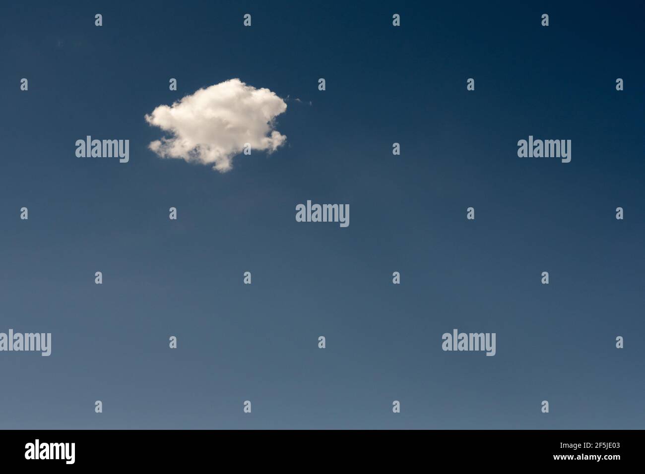 Single Puffy Cloud On Blue Sky with copy space Stock Photo
