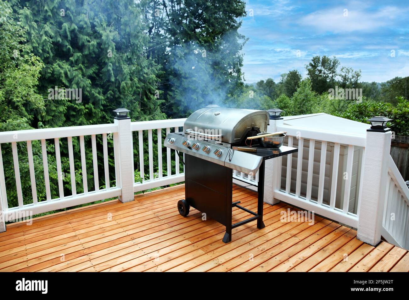 Barbecue cooking with lid closed and visual smoke coming out on outdoor