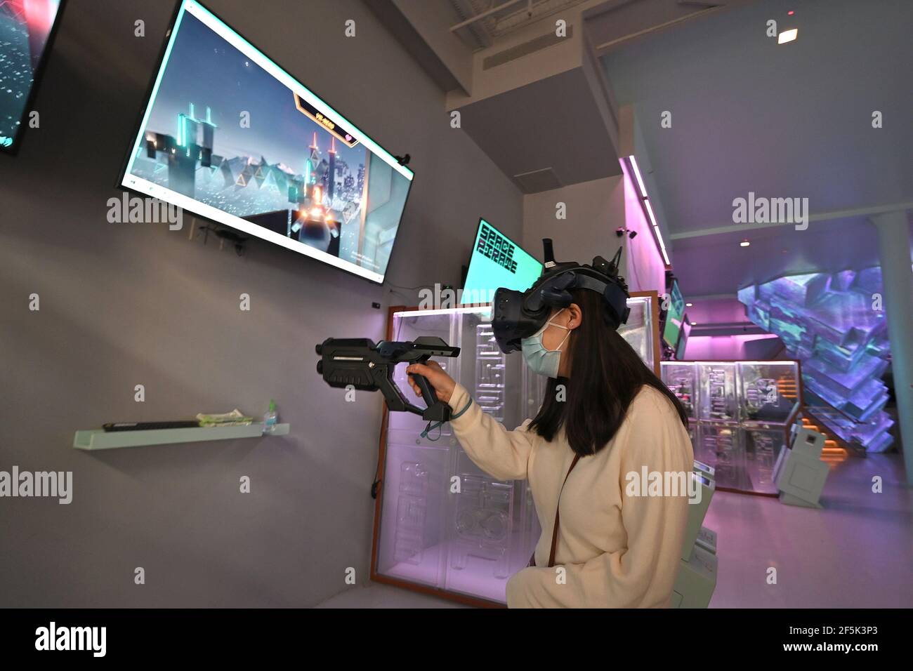 A woman plays a virtual laser tag game at VR World NYC as indoor  entertainment resumes at 25% capacity in New York, NY, March 26, 2021.  Indoor family entertainment centers and places