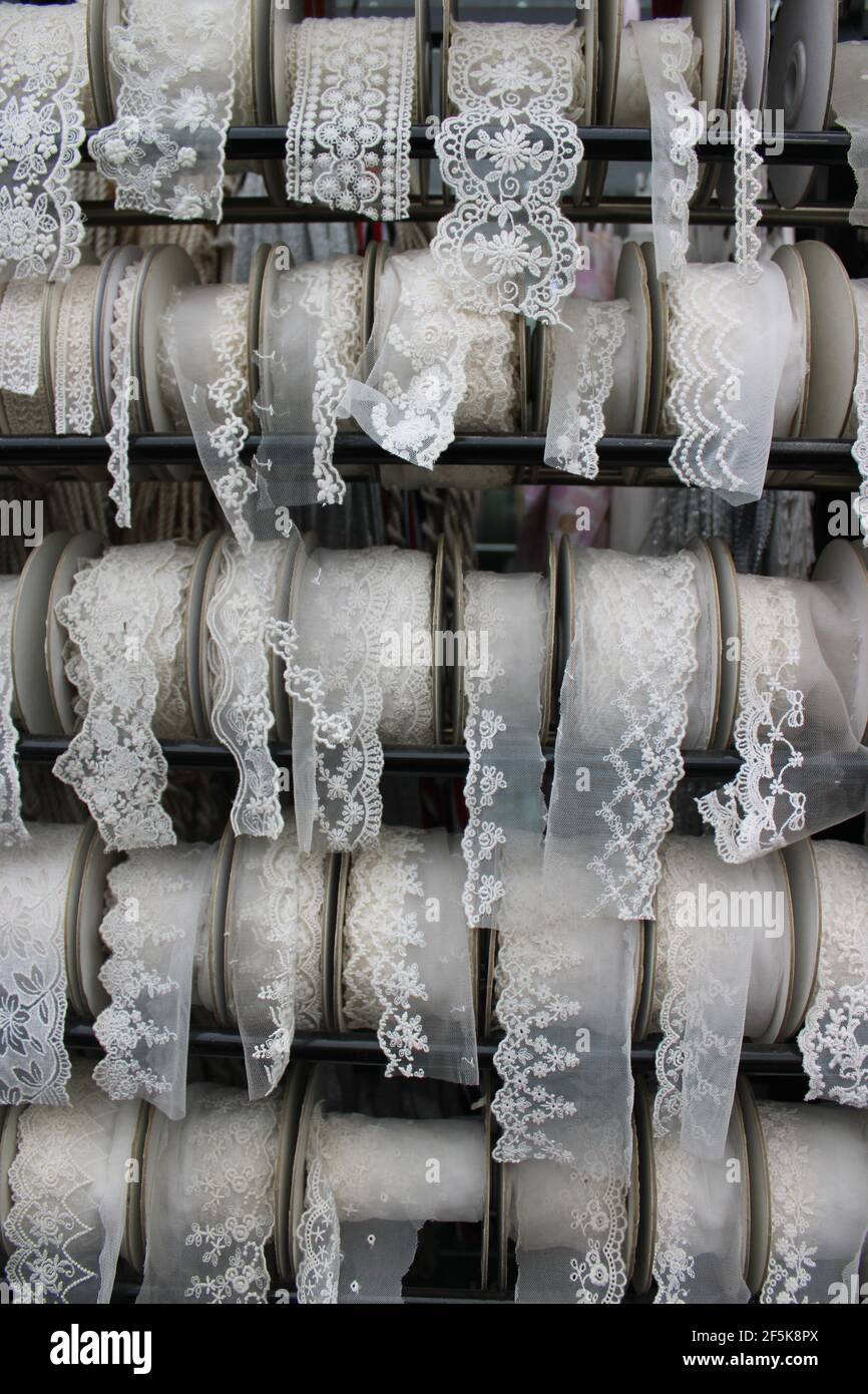 Spools of white and cream lace ribbon, in a textile market Stock Photo