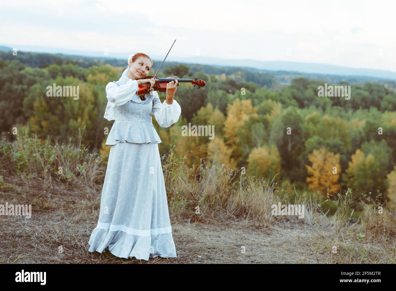 beautiful girl playing violin in white dress in forest Stock Photo - Alamy