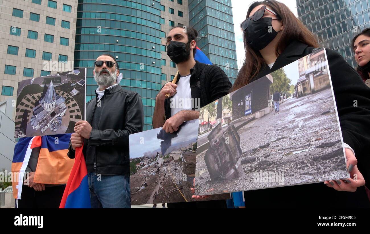 Members of the Armenian community hold photographs of sites in Nagorno Karabakh after they were hit by Azeri army drones during a protest against Israeli weapon sales to Azerbaijan in front of Israel's Defense Ministry on March 26, 2021, in Tel Aviv, Israel. Israel has been accused by Armenia and Armenian supporters of being complicit in Azerbaijan’s policy and knowingly selling drones used to attack civilian populations in the disputed territory of Nagorno-Karabakh during the latest war between Azerbaijan and Armenia. Stock Photo