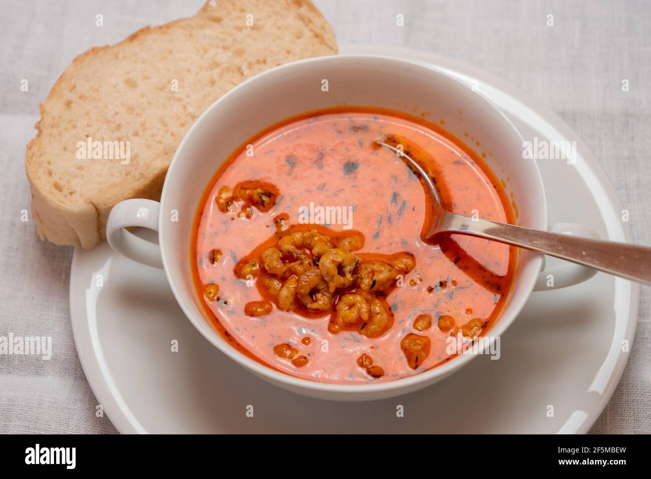Busumer Krabbensuppe, Busom Style Soup with North Sea Crabs in a White Bowl, Served with a Slice of Bread Stock Photo