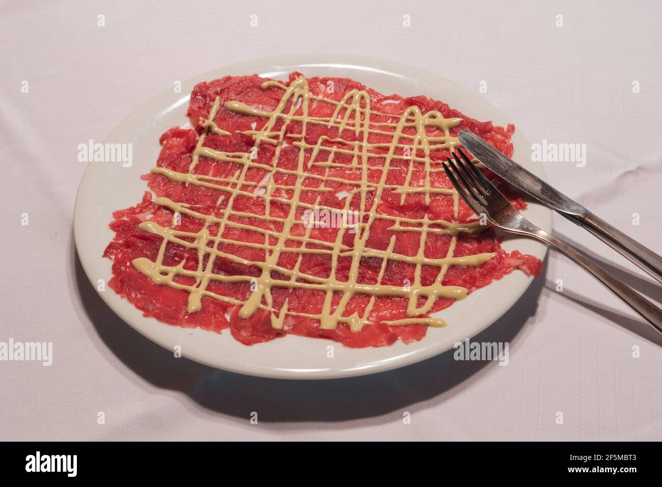 Beef Carpaccio with Mayonnaise Sauce in Classic Cipriani Style on a White Plate Stock Photo