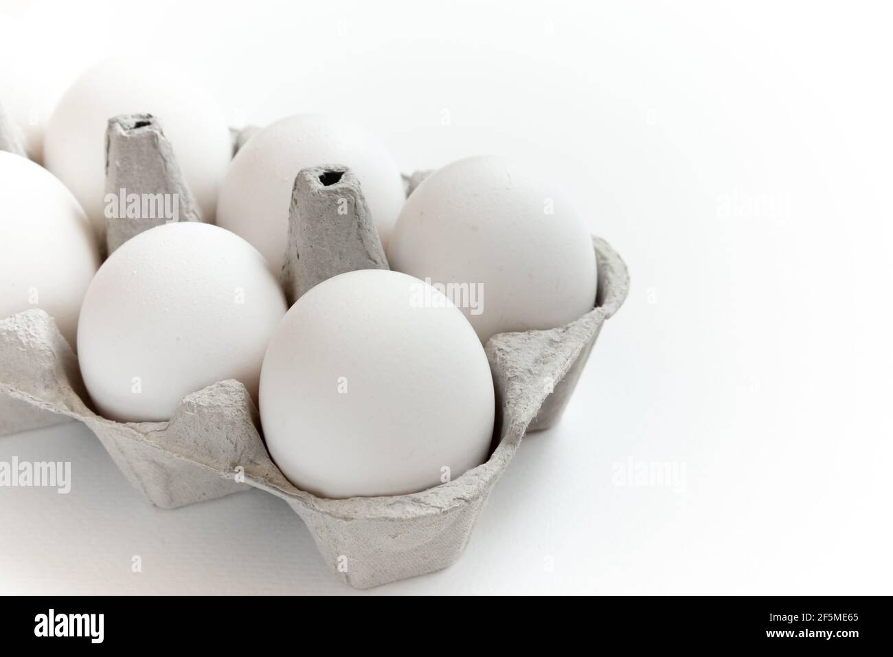 Fresh ginger eggs packed in a gray ecological paper container on a white background. Stock Photo