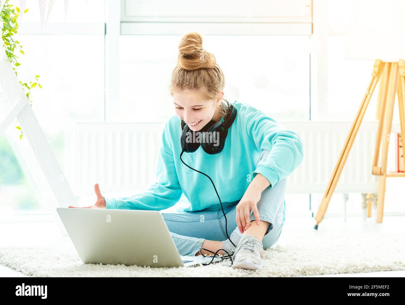 Cute girl using laptop in bright room Stock Photo - Alamy