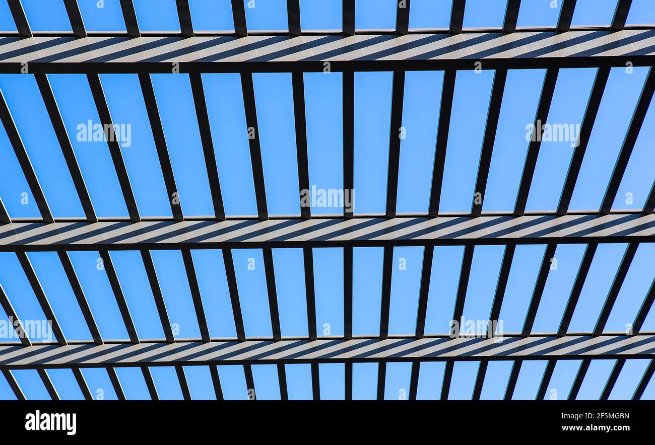 Glass canopy on metal frame.against blue sky background. Stock Photo