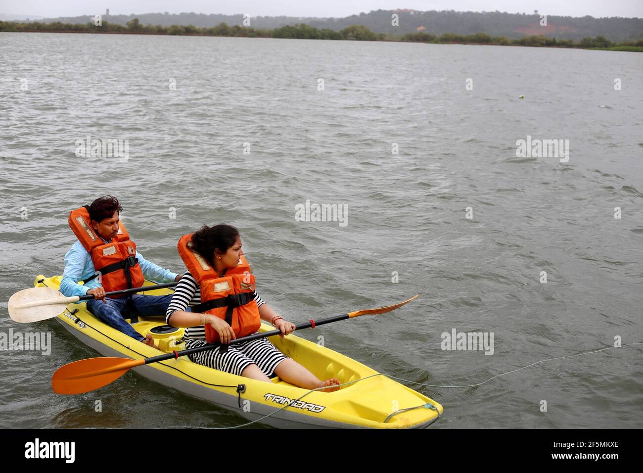Two people rowing on the Mandovi River, Goa, India Stock Photo