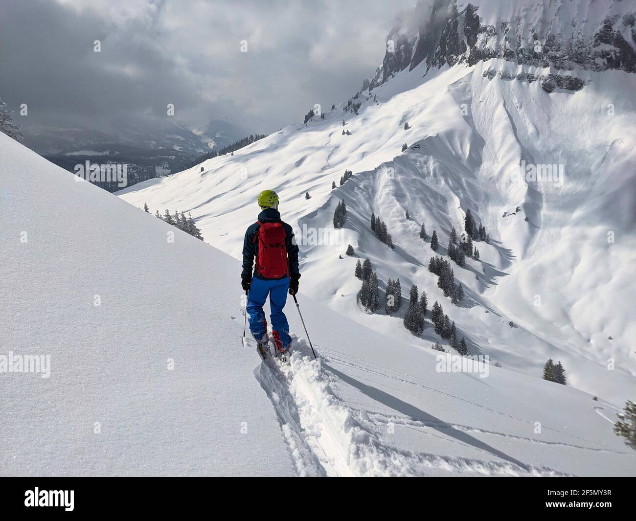 skier draws his own track through the powder snow. Freeride in the mountains of glarus on the silbern. mountaineering Stock Photo