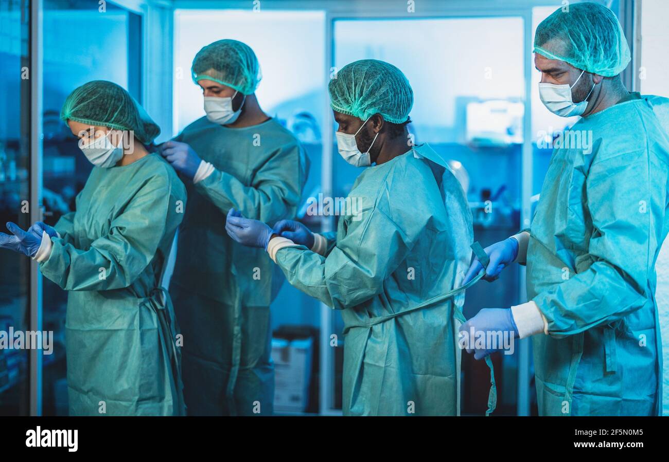 Doctors preparing for surgical operation in hospital during corona virus outbreak - Medical workers getting ready for fighting against coronavirus Stock Photo