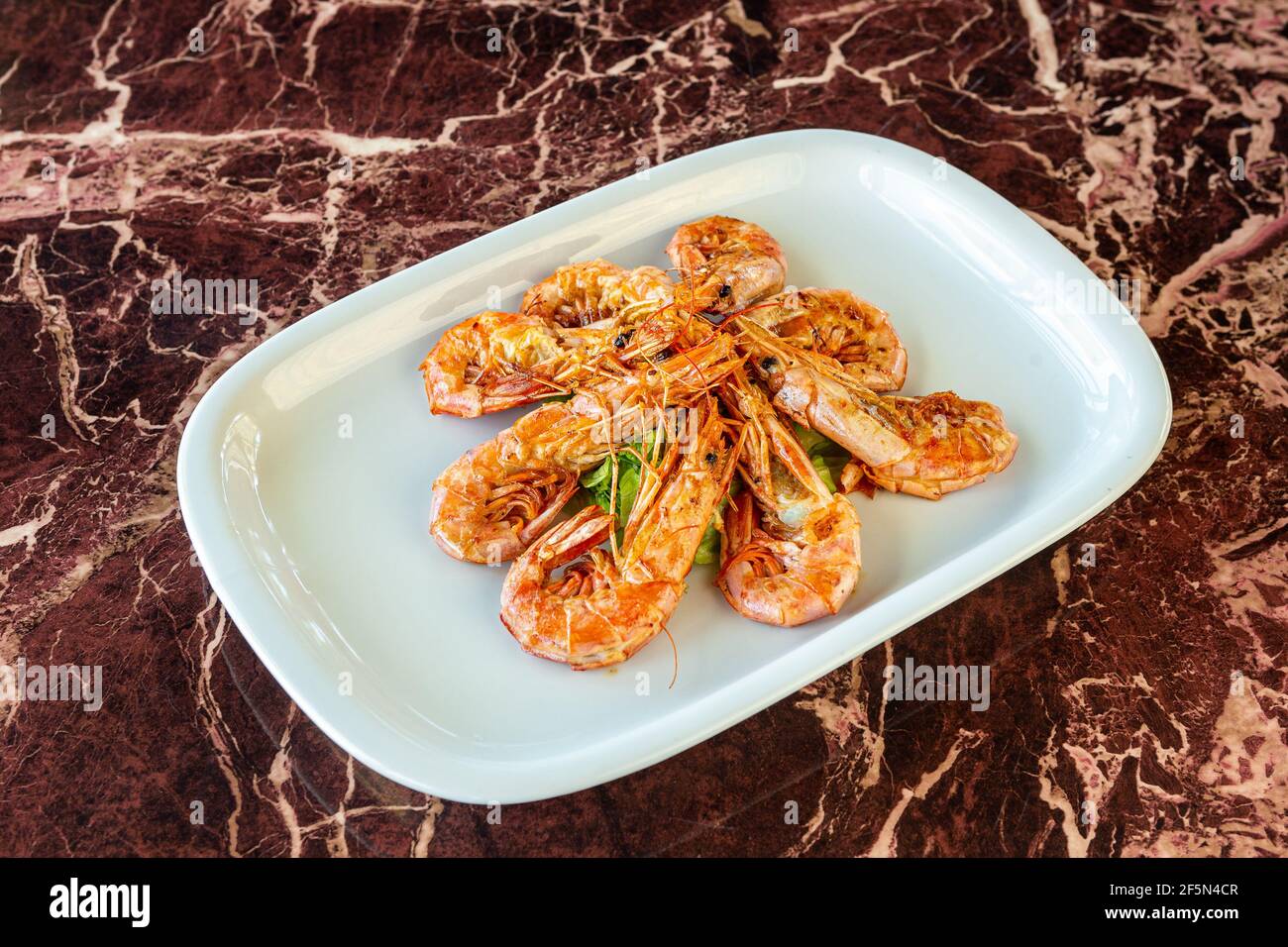 Grilled squid according to traditional Japanese recipes. Copy space. Against the background of a marble table, close-up. Stock Photo
