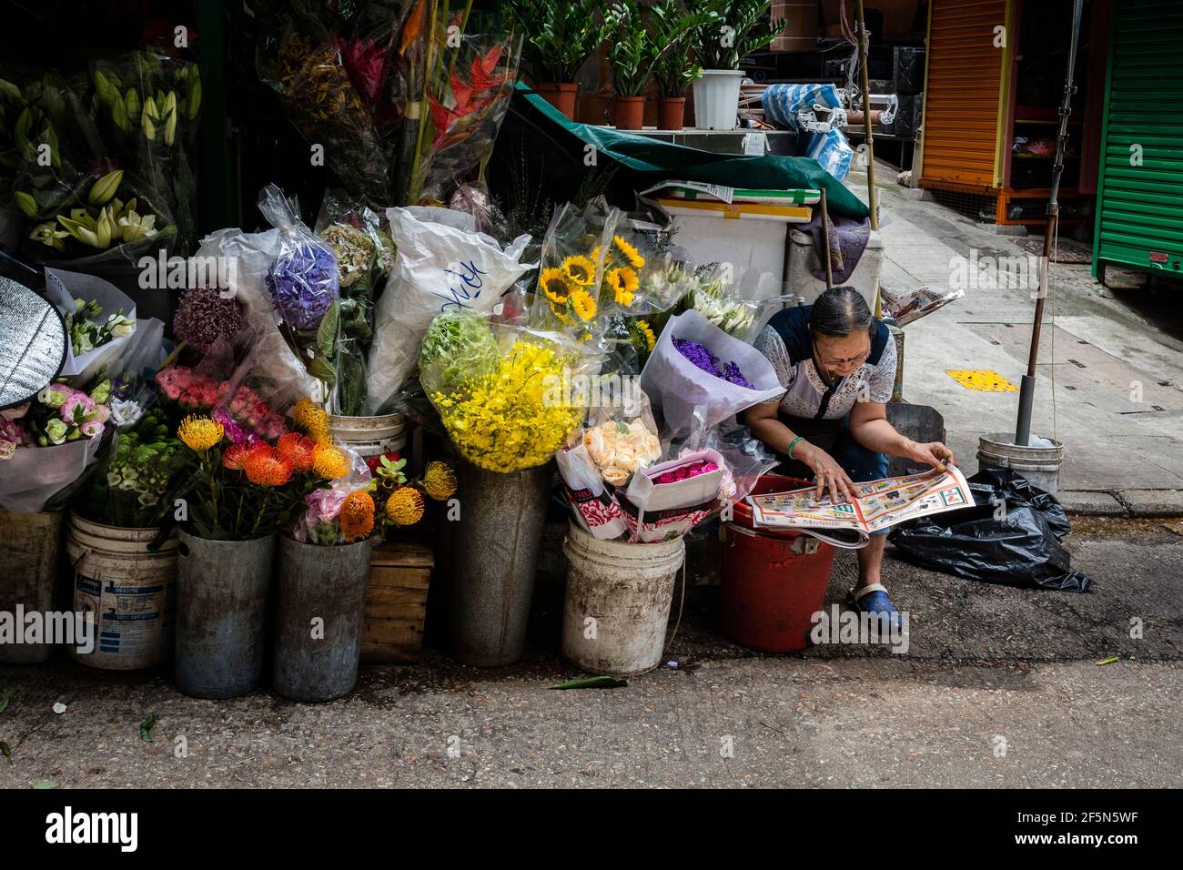 Flower street vendor reading newspaper in Hong Kong Stock Photo Alamy