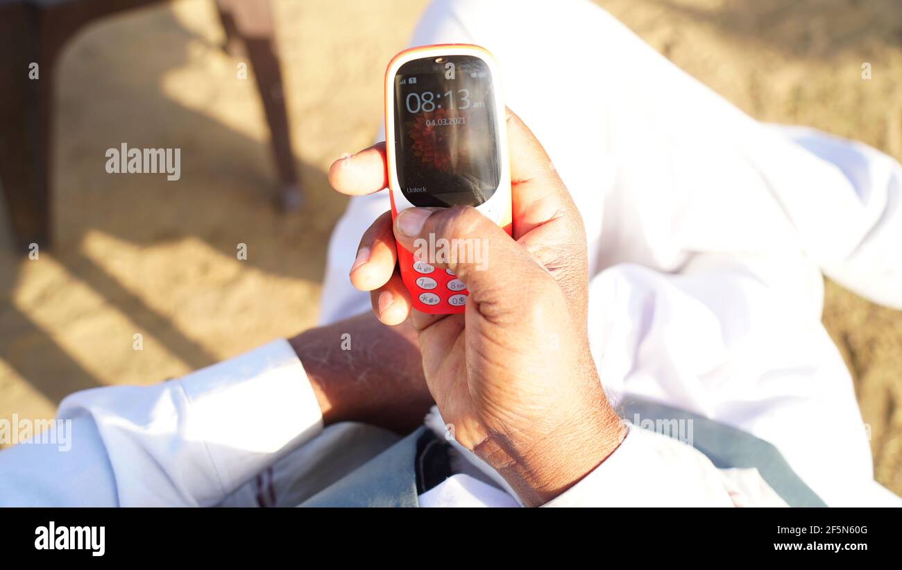 Rajasthan, India - March 21, 2021; Man calling with Nokia old keypad mobile. Nokia 3310 phone in holding in Hand. Close up of people hand using smartp Stock Photo