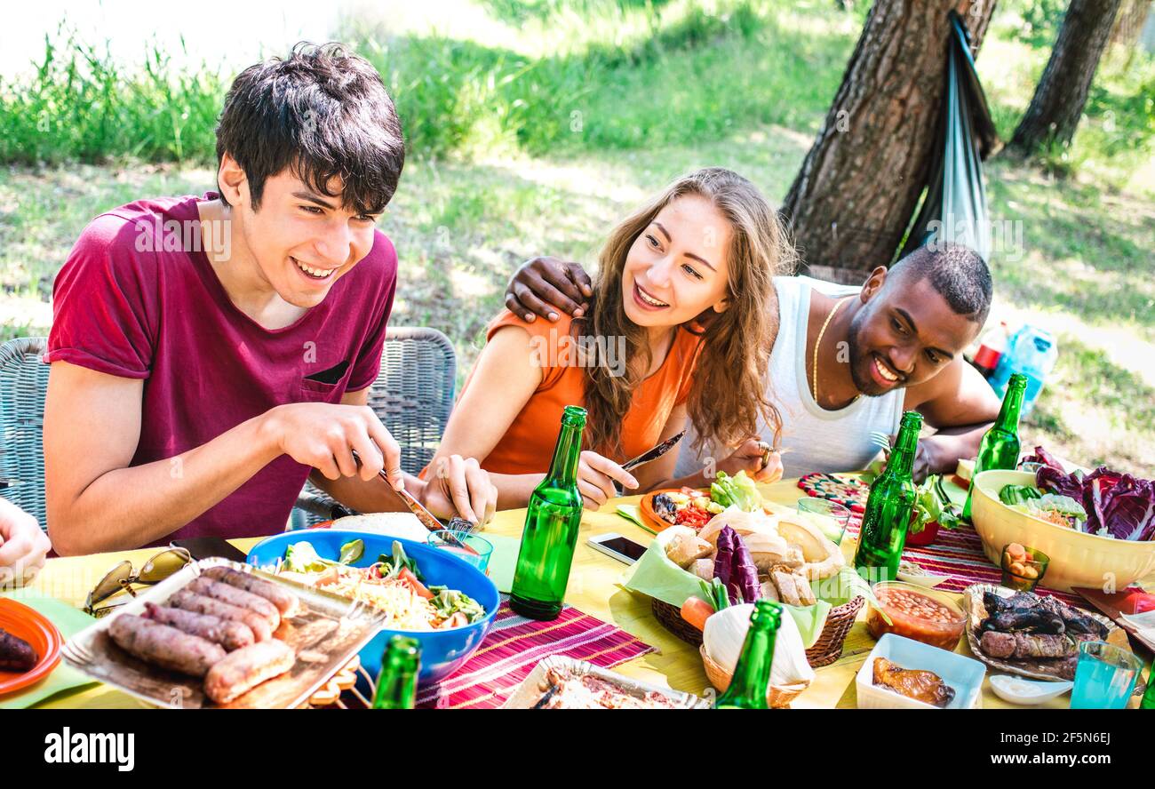 Happy people having fun together at barbecue picnic party - Young multiracial friends at pic nic social gathering - Youth life style concept Stock Photo