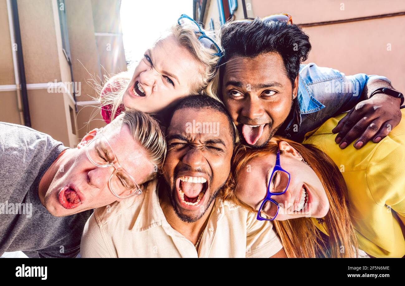 Multiracial millenial people taking selfie sticking out tongue with happy faces - Funny life style concept against racism Stock Photo
