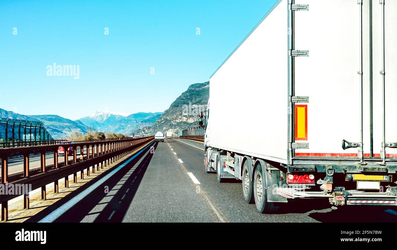 Semi truck speeding on empty highway line - Transport logistic concept with semitruck container driving on speedway Stock Photo