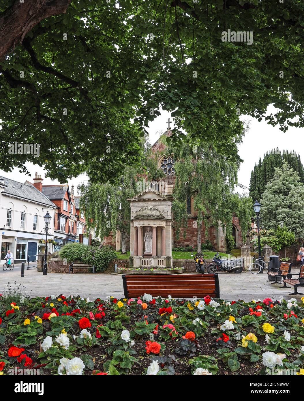 The Queen Anne statue in Wellington Square, Minehead. Seating for those wishing to rest. A couple of visitors have used it to rest their motorbikes Stock Photo