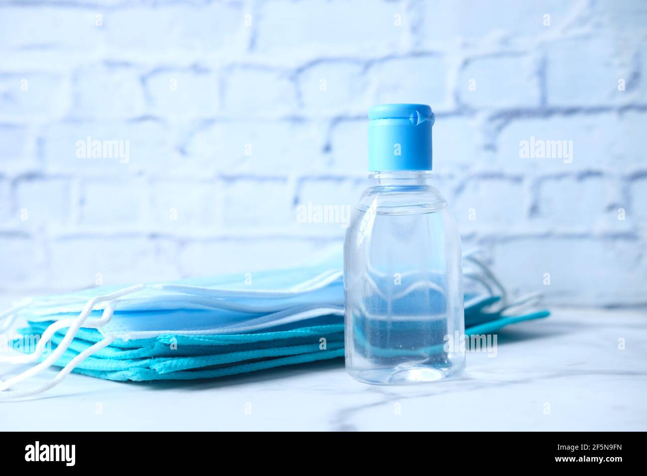Surgical masks, and hand sanitizer on white background Stock Photo - Alamy