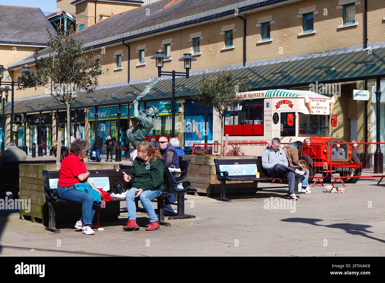 Hastings, East Sussex, UK. 27 Mar, 2021. UK Weather: People sitting on benches enjoying the sunshine in priory meadow shopping centre, queens square. Photo Credit: Paul Lawrenson /Alamy Live News Stock Photo