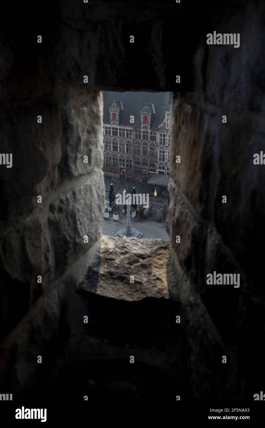 A view of Sint veerleplein from a narrow stone window slit in the Gravensteen, a 10th Century castle in Ghent, Belgium. Stock Photo