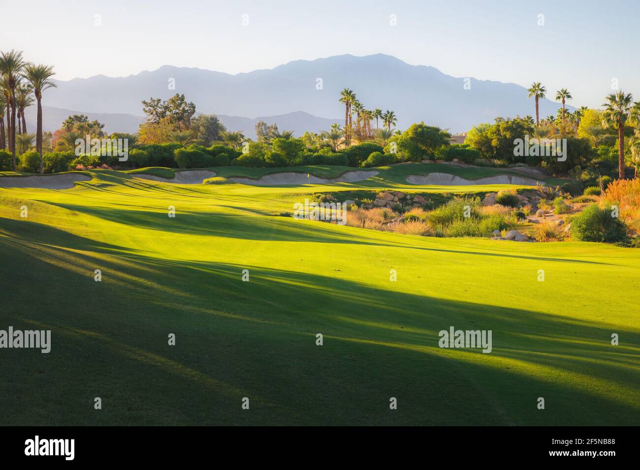 Beautiful golden light over Indian Wells Golf Resort, a desert golf course in Palm Springs, California, USA with view of the San Bernadino Mountains. Stock Photo