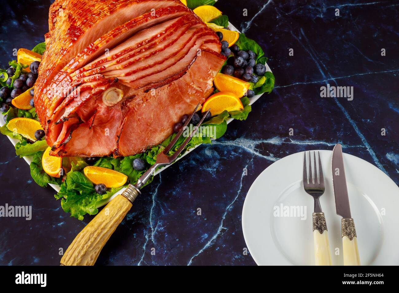 Delicious honey smoked pork ham with table setting. Stock Photo