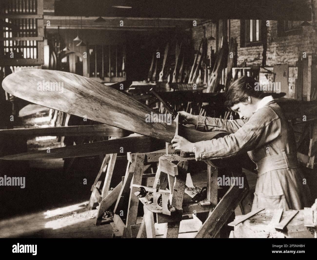 In a British factory, a young woman applying carpentry skills to the production of an aircraft propellor during World War One. Stock Photo