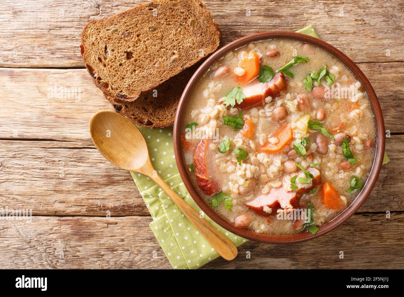 Homemade Ricet barley and bean soup with smoked meat and vegetables close-up in a bowl on the table. horizontal top view from above Stock Photo