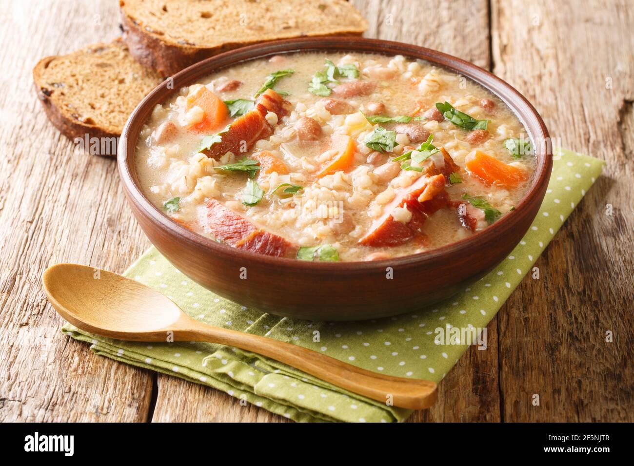 Delicious ricet dish barley and bean with meat and vegetables close-up in a bowl on the table. horizontal Stock Photo