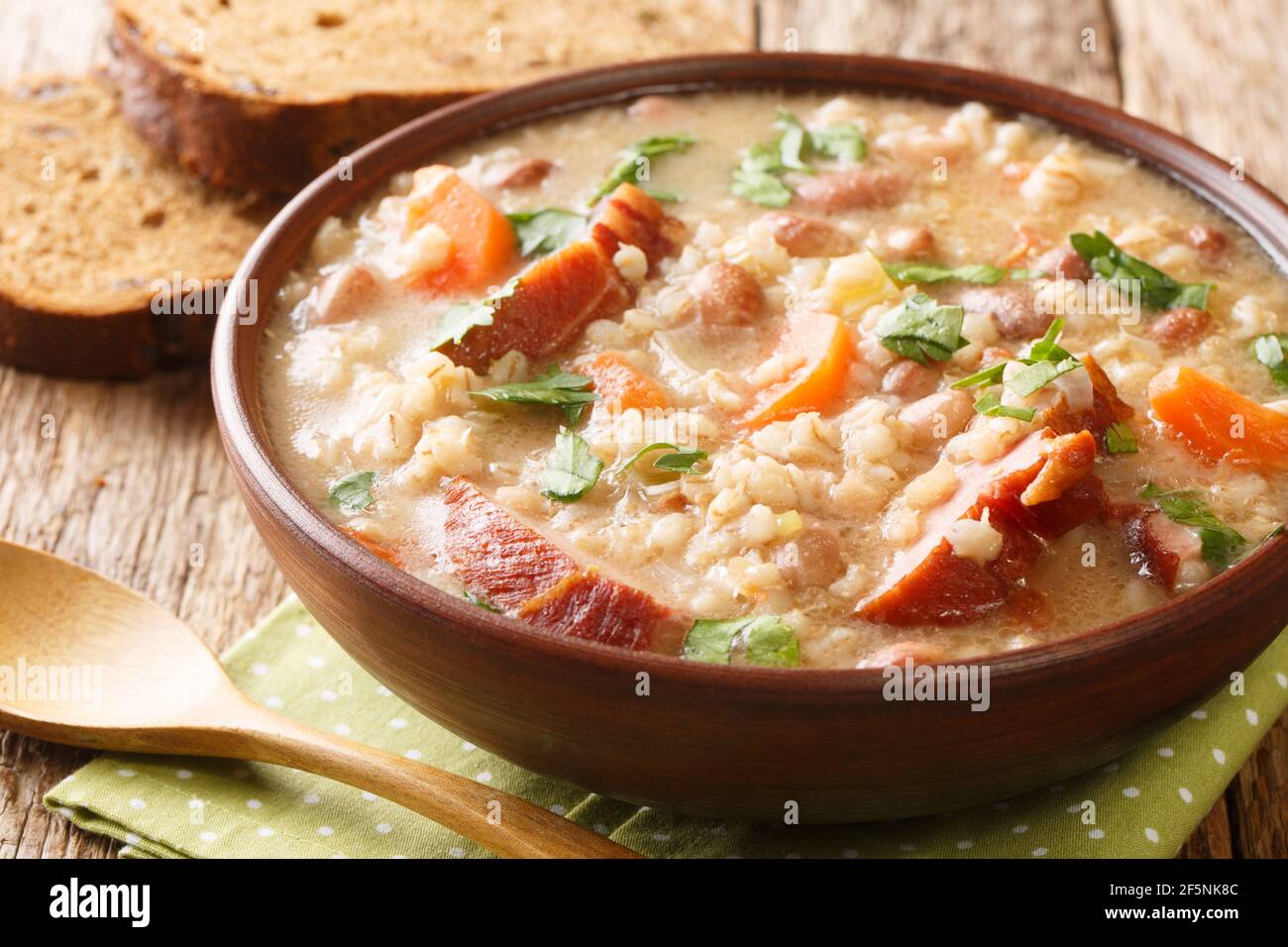 Homemade Ricet barley and bean soup with smoked meat and vegetables close-up in a bowl on the table. horizontal Stock Photo