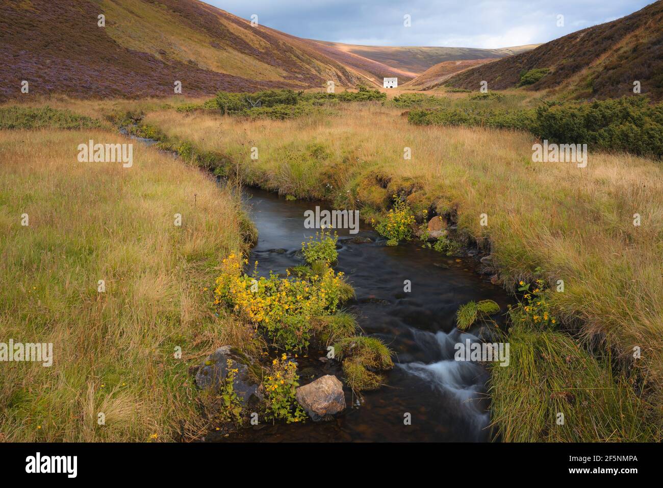An old abandoned mining site, Lecht Mine and stream in the rolling hills countryside landsacpe of Cairngorms National Park, in the Scottish Highlands Stock Photo