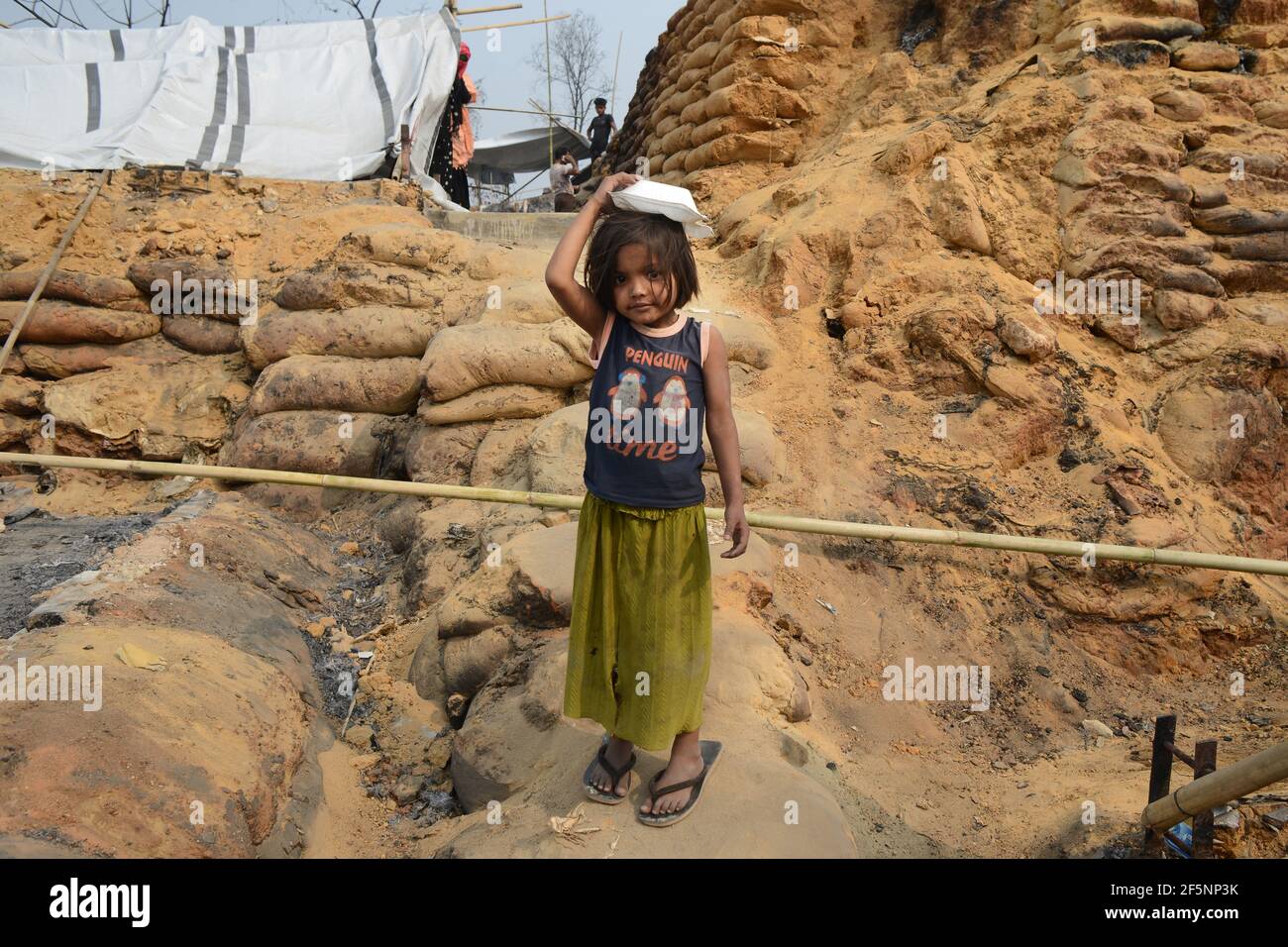 A child seating on open sky after a huge fire swept through a Rohingya refugee camp in southern Bangladesh on Monday, destroying thousands of homes an Stock Photo